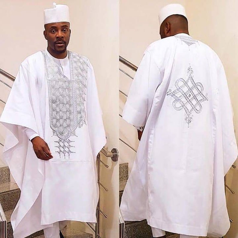 Puede incluir: Un atuendo tradicional masculino blanco con bordados plateados. El atuendo incluye una camisa de manga larga, pantalones y una gorra. La camisa tiene un dise&ntilde;o decorativo en la parte delantera y trasera.
