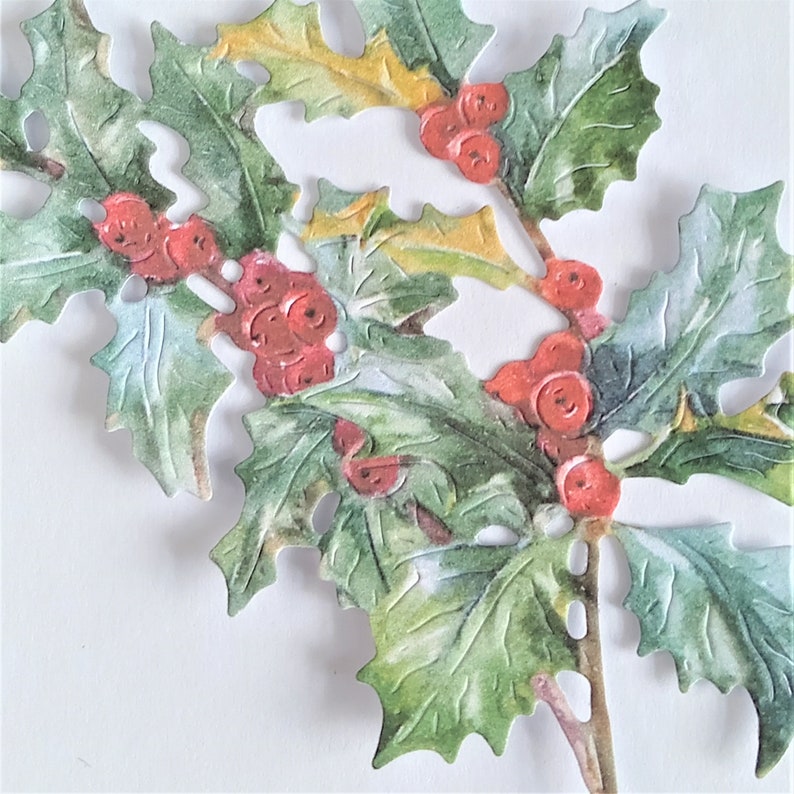 May include: A close-up of a holly sprig with red berries and green leaves. The leaves are painted in a watercolor style and have a textured look.