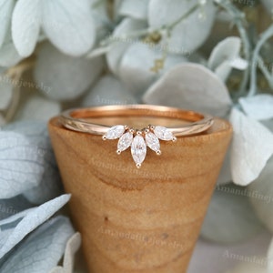 Op de afbeelding: Een delicate band van ros&eacute;goud met een gebogen rij marquise-vormige diamanten. De diamanten zijn gezet in een kraalbezetting en cre&euml;ren een prachtig, sprankelend ontwerp.