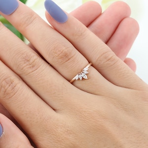 Op de afbeelding: Een delicate ring van ros&eacute;goud met een marquise-vormig diamantclusterontwerp. De diamanten zijn in een aflopend patroon gezet, wat een unieke en elegante uitstraling cre&euml;ert.