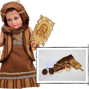 May include: A brown and tan doll dressed in a traditional outfit with a basket and a wooden plaque with a carved image of Jesus. The doll is wearing a brown head covering and a brown and tan dress with a brown belt. The doll is holding a basket in one hand and a wooden plaque in the other hand. The plaque has a carved image of Jesus on it.
