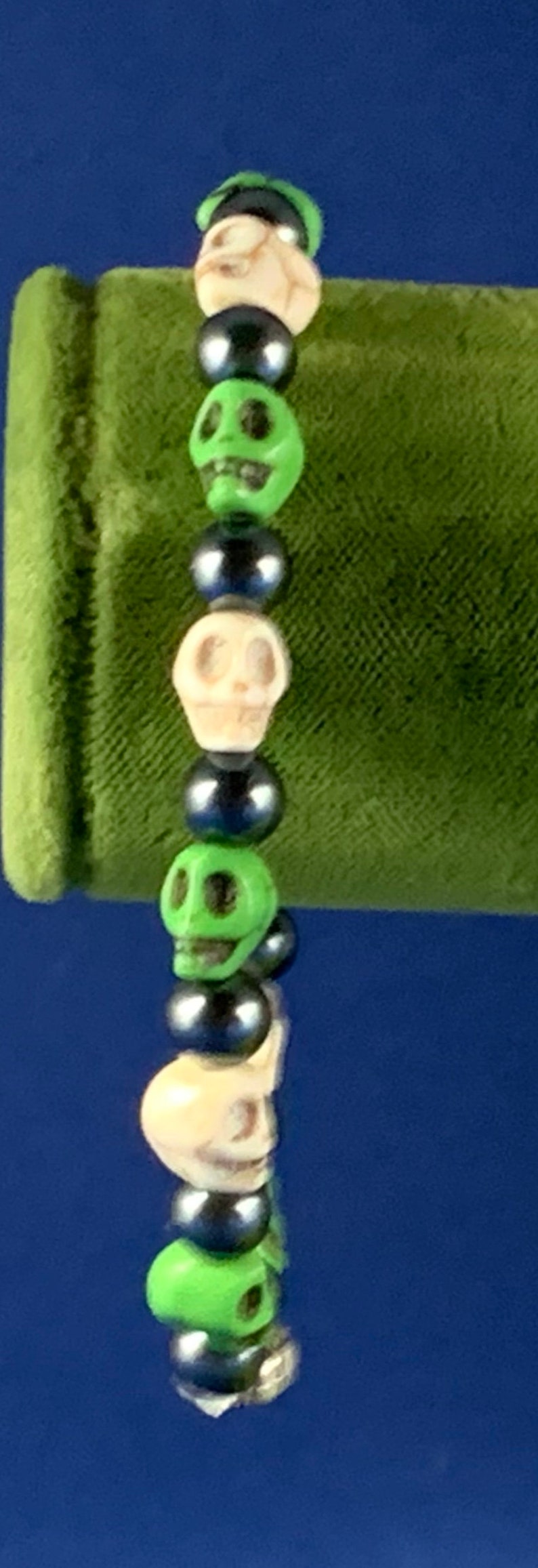 Smiling skulls of green and white separated by black hematite beads