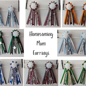 Op de afbeelding: Een set Homecoming Mum oorbellen met verschillende schoolkleuren en namen, waaronder "COBRAS", "BUCS", "DRAGONS", "COACH" en "SOPHIE".