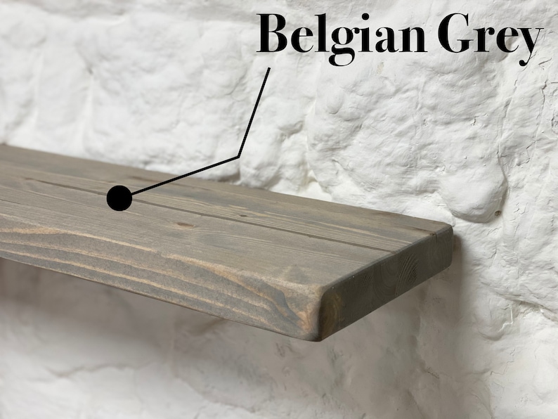 May include: A close-up of a wooden shelf in a gray stain called "Belgian Grey". The shelf is made of natural wood with visible grain and knots.