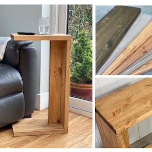 May include: A wooden side table with a unique design. The table has a rectangular top and a curved arm that extends out from the side. The table is made of natural wood and has a light brown finish.