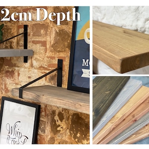 May include: A set of wooden shelves with black metal brackets. The shelves are 22 cm deep and come in a variety of wood finishes, including natural, grey, and dark brown. The shelves are shown mounted on a brick wall.