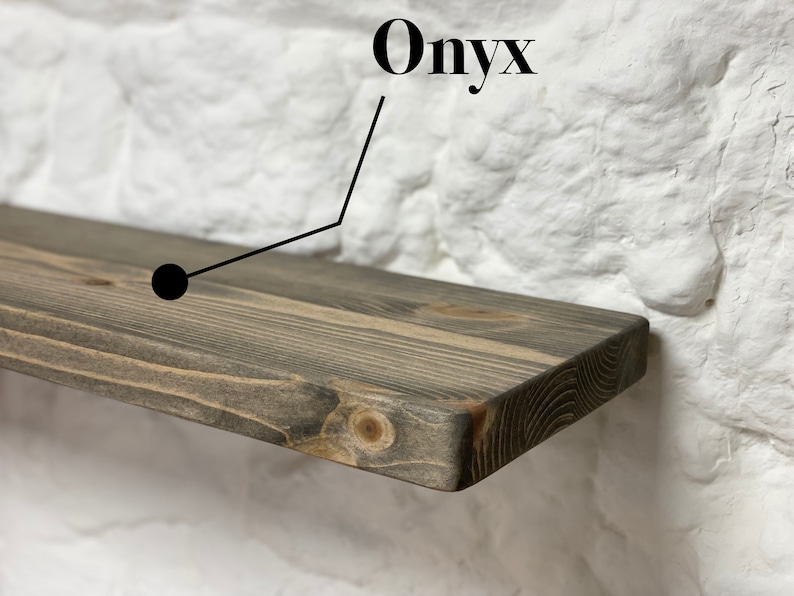 May include: A dark gray wooden shelf with a slightly rounded edge. The shelf is labeled "Onyx" in black text.