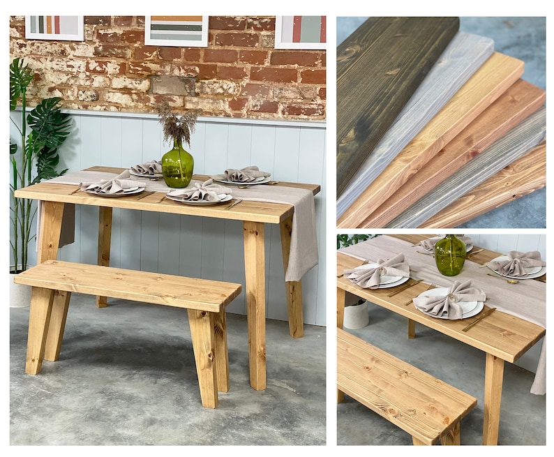 May include: A rustic wooden table and bench set with a light brown finish. The table is set with a light gray linen tablecloth and napkins, a green glass vase with greenery, and gold flatware. The bench is made of the same wood as the table and has a simple design.