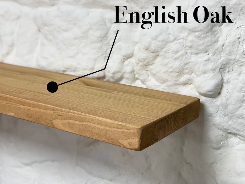 May include: A close-up of a light brown wooden shelf made of English Oak. The shelf is mounted on a white brick wall.
