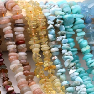 Puede incluir: Surtido de cuentas de chips de piedras preciosas en varios colores, incluyendo rosa, marrón, amarillo, azul y verde. Las cuentas están enhebradas en una cuerda y están listas para ser utilizadas para la elaboración de joyas.