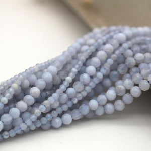 Könnte beinhalten: Eine Strähne aus hellblauen Edelsteinperlen. Die Perlen sind facettiert und haben eine leicht unregelmäßige Form.