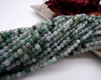 May include: A strand of green and white agate beads. The beads are round and have a smooth, polished finish.