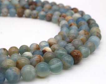 May include: A strand of round, blue and brown agate beads. The beads have a mottled, marbled appearance.