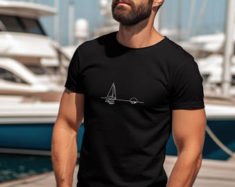 Peut inclure: Un t-shirt noir avec un dessin au trait blanc d'un voilier et d'un soleil couchant sur l'eau.