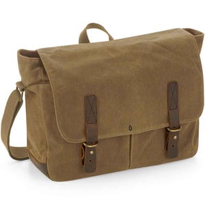 May include: A brown canvas messenger bag with a flap closure and adjustable shoulder strap. The bag has two leather straps with buckles and a small handle on top. The bottom corners are reinforced with brown leather.