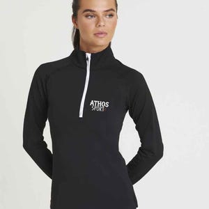 May include: Black long-sleeve shirt with a white zipper and white trim. The shirt has the text "ATHOS SPORT" in white lettering on the front.