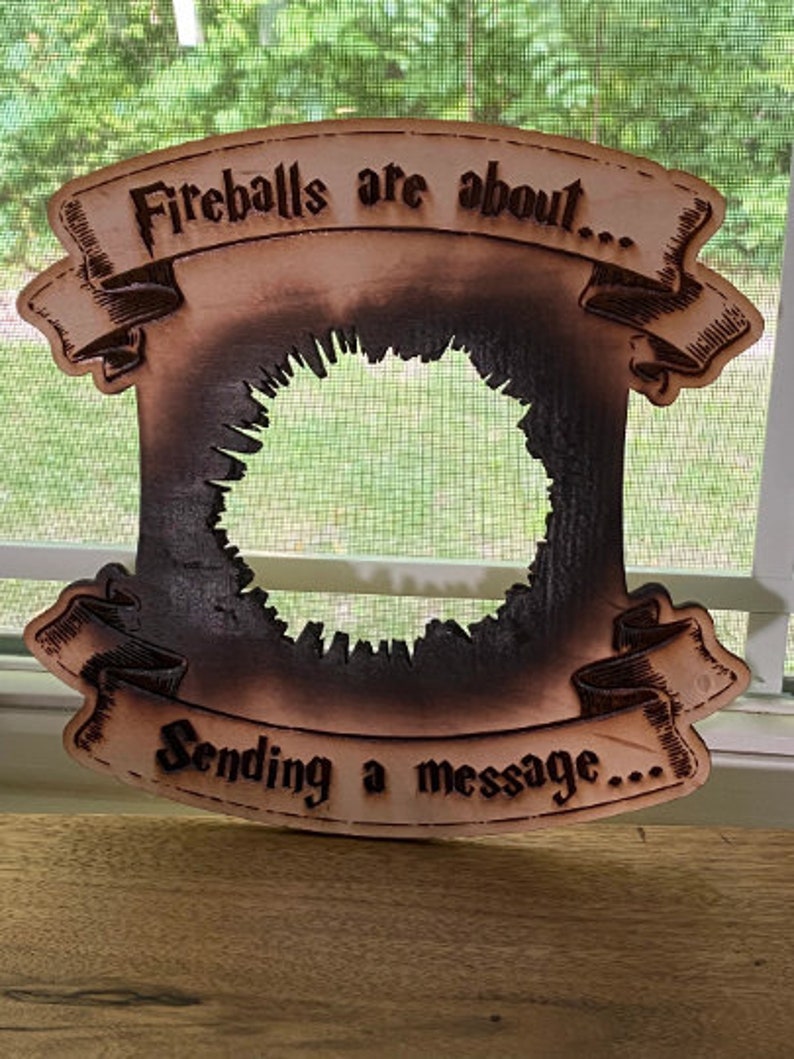 May include: A wooden sign with a burnt-out centre, featuring the text "Fireballs are about... Sending a message..." in a vintage font.
