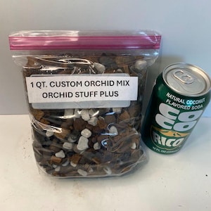 May include: A clear plastic bag filled with orchid mix, labeled "1 QT. CUSTOM ORCHID MIX ORCHID STUFF PLUS." Next to it is a green can of "RICO" natural coconut flavored soda, 12 fl oz.