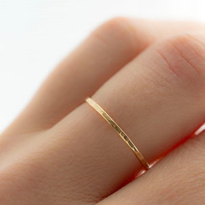 Puede incluir: Un fino anillo de banda de oro con textura martillada.