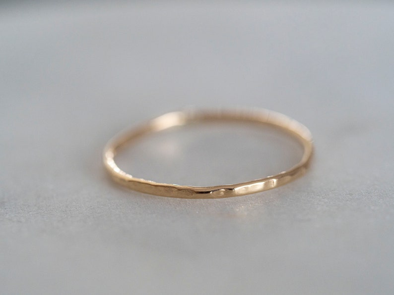 Puede incluir: Un anillo de banda de oro simple con una textura martillada.