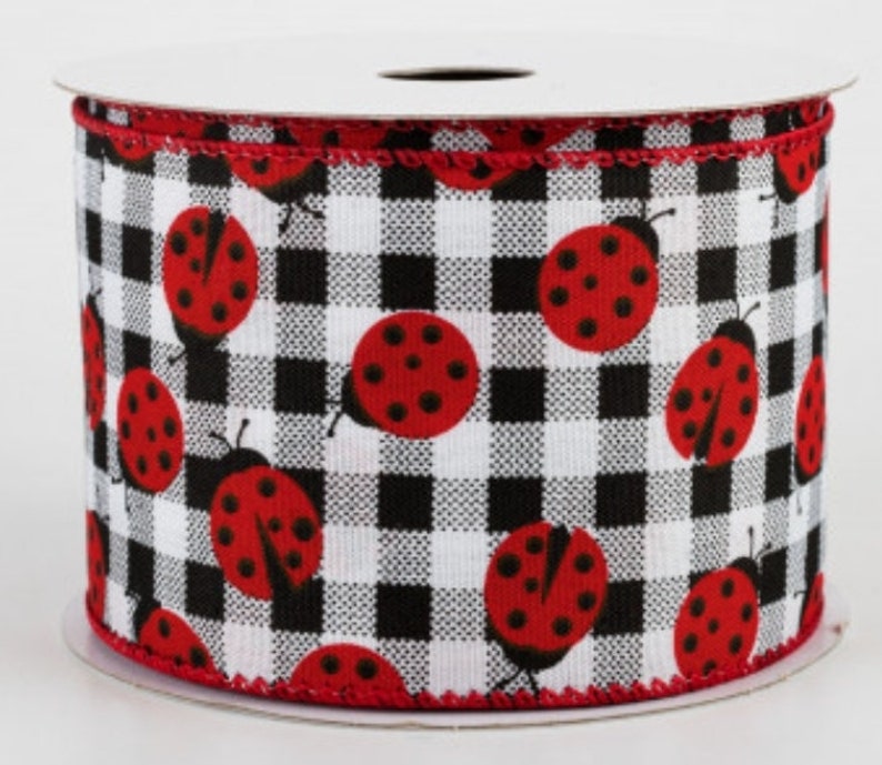 May include: A roll of white and black buffalo plaid ribbon with red ladybugs printed on it.