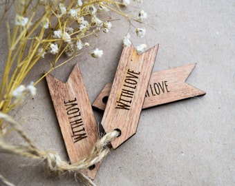 May include: Two wooden tags with the text "With Love" on them. The tags are tied together with twine and are on a brown background.