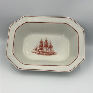 May include: A white octagonal ceramic serving dish with a red rope design around the edge. The dish features a red line drawing of a sailing ship in the centre.