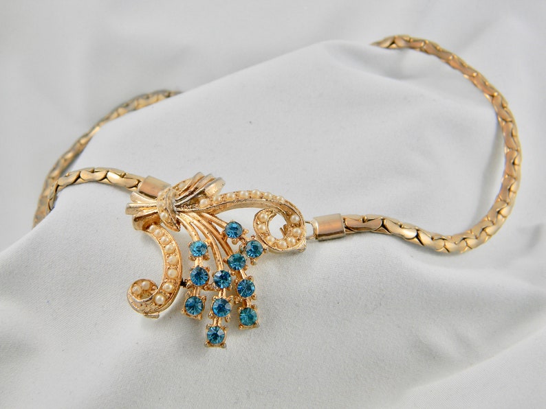 Vintage gold coloured necklace with synthetic pearl and rhinestone accents. image 1