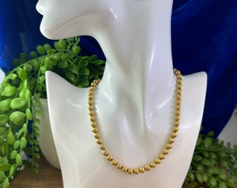 Gold tone Trifari 17” diamond cut ball necklace.