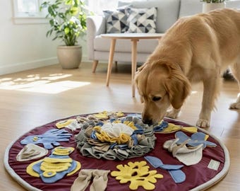 May include: A round, burgundy fabric snuffle mat for dogs featuring a central cluster of layered felt strips in yellow, white, and gray, surrounded by various sewn-on felt shapes including blue octopus, yellow coral, and beige leaf designs.