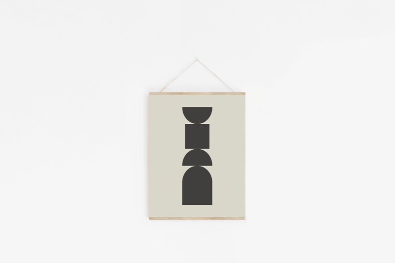 May include: A framed print with a minimalist design featuring a stack of black geometric shapes on a light green background.