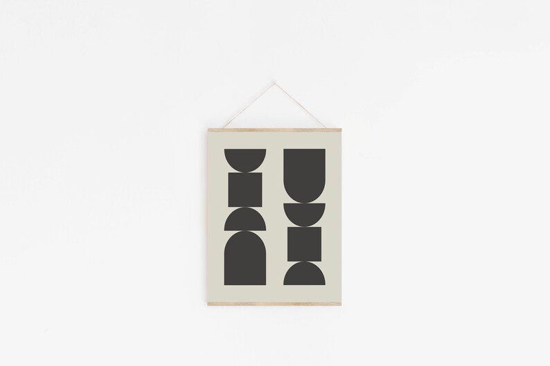 May include: A black and white geometric print with abstract shapes in a minimalist style. The print is framed and hanging on a white wall.