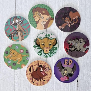 May include: Eight circular coasters featuring characters from Disney's The Lion King. The coasters depict Simba, Timon, Pumbaa, Scar, and other characters in bright colours. Each coaster has a unique background design.