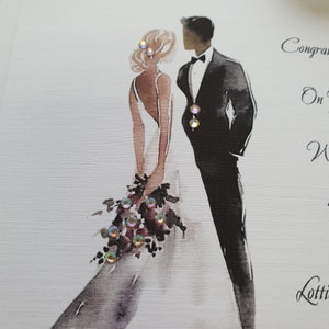 May include: A wedding card with a watercolor illustration of a bride and groom. The bride is wearing a white dress and holding a bouquet of flowers. The groom is wearing a black tuxedo. The card has the text "Congratulations on your Wedding" and "Lots of love".