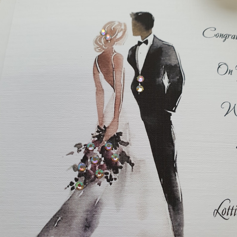 May include: A wedding card with a watercolor illustration of a bride and groom. The bride is wearing a white dress and holding a bouquet of flowers. The groom is wearing a black tuxedo. The card has the text "Congratulations on your Wedding" and "Lots of love".