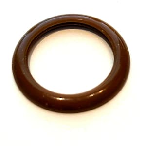 May include: A brown ring-shaped object with a glossy surface. The ring has a hollow centre and a dark brown colour. The surface appears smooth and reflective. The object is set against a white background.