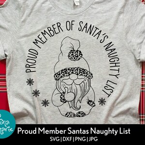 May include: A gray t-shirt with a black and white graphic of a gnome wearing a hat with a leopard print. The text "Proud Member of Santa's Naughty List" is written in a circle around the gnome.
