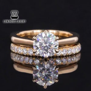 May include: A rose gold engagement ring set with a large, round, brilliant cut diamond center stone and a matching rose gold band with smaller diamonds set in a pave setting.