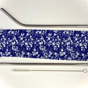 Pode incluir: Um conjunto de duas palhas de a&ccedil;o inoxid&aacute;vel com uma escova de limpeza e uma caixa de transporte com padr&atilde;o floral azul e branco.