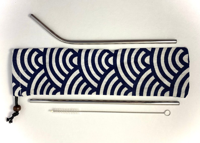 Pode incluir: Um conjunto de tr&ecirc;s canudos de beber de a&ccedil;o inoxid&aacute;vel com uma escova de limpeza e uma bolsa de transporte de tecido azul e branco.