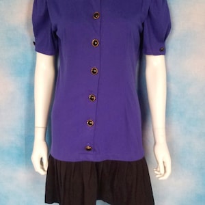May include: A purple short-sleeved dress with a black skirt and gold buttons.