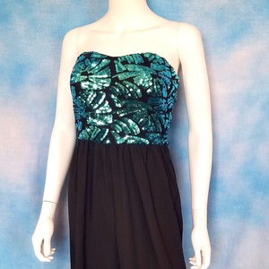 May include: A strapless maxi dress with a black skirt and a sequined bodice in shades of teal and green.