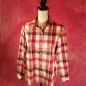 May include: A long-sleeved plaid shirt with a button-down collar. The shirt is a mix of red, white, brown, and blue plaid.