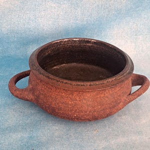 May include: A white ceramic mug with a black handle and the text "But First, Coffee" in a black, bold font. The mug is sitting on a white surface. The mug is 4 inches tall.