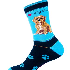 Op de afbeelding: Een blauw-zwarte sok met een hondenafbeelding. De sok heeft een lichtblauwe achtergrond met een bruine hondenillustratie en de tekst "I ❤️ My Dog". De sok heeft ook blauwe pootafdrukken.