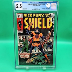 May include: A comic book cover featuring Nick Fury, Agent of S.H.I.E.L.D. The cover is in a graded plastic case with a CGC label. The cover art shows Nick Fury in a yellow and orange costume, holding a rifle, with other characters in the background. The text on the cover reads "Nick Fury, Agent of S.H.I.E.L.D." and "The Assassination of Nick Fury!"