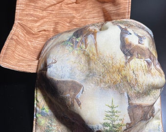 May include: A brown and tan fabric bowl liner with a deer print. The liner has a brown fabric backing.