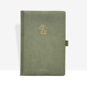 Könnte beinhalten: Olivgrünes Notizbuch mit goldenem Pilzdesign und dem Wort "JOURNAL" unten. Das Notizbuch hat einen passenden elastischen Verschluss.