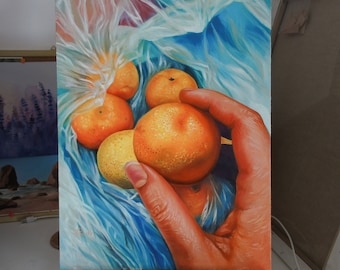 May include: A painting of a hand holding a bag of oranges. The oranges are a bright orange color and the bag is a blue and white plastic bag. The painting is on a wooden easel.