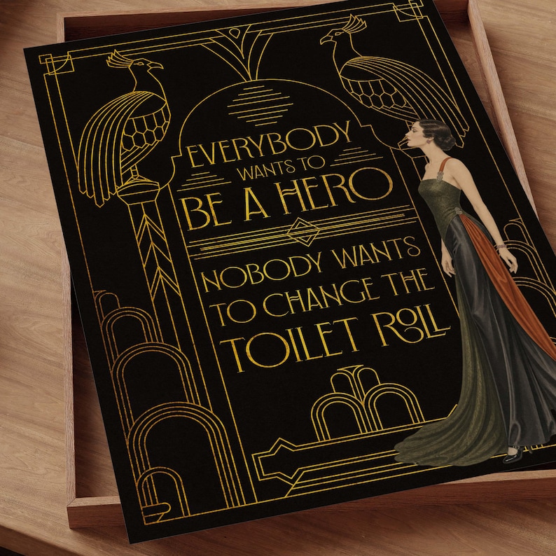 Pu&ograve; includere: Una stampa rettangolare nera con linee dorate che raffigura due pavoni e una persona con un abito lungo. Il testo recita: EVERYBODY WANTS TO BE A HERO NOBODY WANTS TO CHANGE THE TOILET ROLL. Il design include archi geometrici e bordi decorativi.